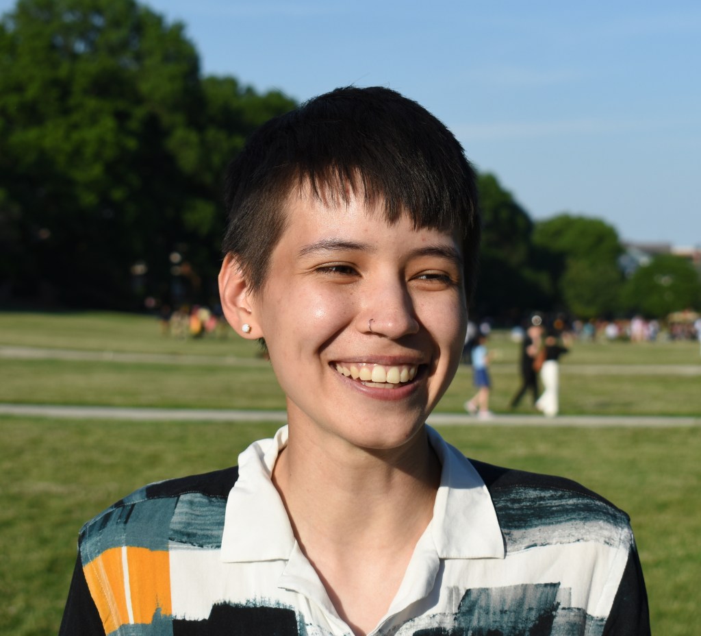 Headshot of Monika smiling outside on a sunny day.